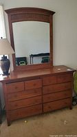 Full front view of the 8 drawer dresser with attached mirror showing wooden construction, drawer layout, and finish.