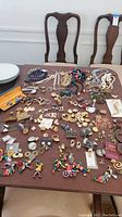 Overview of the lot's costume jewelry spread out on table with some chairs in background