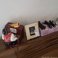 Wide view showing Jazz Piano Man figurine at piano, Gloria Todd Jones signed artwork, and three black Enesco figurines on boxes.