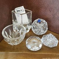Photo of all five glass items including the Kosta Boda candle holder, bowl, vase, and two paperweights on wooden surface
