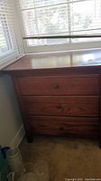 Full frontal image of the 3 drawer nightstand showing natural wood grain and three wooden knobs on drawers
