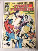 Image of the front cover of Marvel Transformers comic book issue #2, showing detailed colorful artwork featuring Optimus Prime and Megatron.