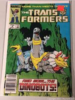 Front cover of Marvel Transformers comic book number 8 showing the Dinobots on the cover in a cave.