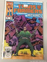 Front cover of Marvel Transformers comic book issue 26 showing character The Mechanic with robot parts in the background