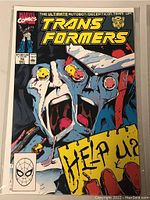 Front cover of Marvel Transformers comic book number 70 with 'Help Us?' text and distressed face artwork.
