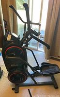 Side view of Bowflex Max Trainer elliptical showing the foot pedal, handles, and main body with branding visible.