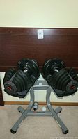 Front view of dumbbells on stand with headboard in background
