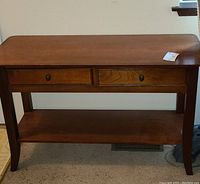 Full frontal view of the brown wooden console table showing two drawers and the lower shelf.
