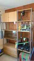 Full view of the storage unit showing wooden cabinets, glass display cabinet, wooden drawers, and metal shelving unit with various items (not included).