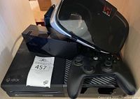 Xbox One console with charger, controller, and VR Wear headset displayed together