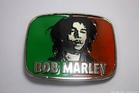Front view of the rectangular Bob Marley belt buckle showing raised black profile and colored enamel backgrounds with name.