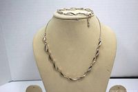 Full display of gold-tone twisted necklace with rhinestone accents shown on bust form.