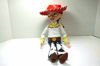 Full seated body view of Jessie doll showing outfit, boots, and large red hat.