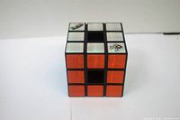Rubik's Cube Techno Source cube showing orange and reflective silver stickers, cube in normal solved state.