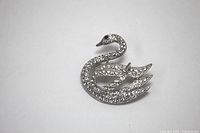 Top-down view of swan brooch fully adorned with clear rhinestones on a white background, showing detail and overall shape.