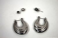 Photo showing the pair of large sterling silver hoop earrings with ridged design and small round stud earrings, displayed on white background.