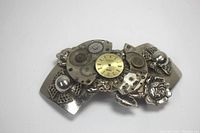 Top angle view of metal hair barrette showing central clock face with gears and roses on the sides.