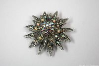 Front view of silver tone brooch with AB rhinestones, showing starburst design and iridescent stones.