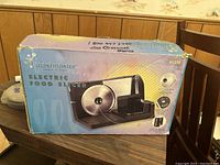 Box of TruMaster Electric Food Slicer model 61223 showing product image and features on front of box