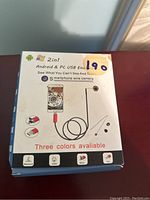 Box of a 2-in-1 Android and PC USB endoscope wire camera with a flexible cable and small camera lens at the end, showing compatibility logos and product features.