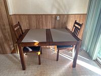 Front view photo of wooden table with two chairs showing table top and chair design