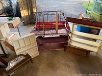 Photo showing multiple assorted shelves including a red shelf, a white shelf, metal wine rack, and wooden pieces.