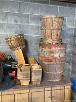 Stack of various sized wooden baskets including 5 bushel, half bushel, and quart baskets.