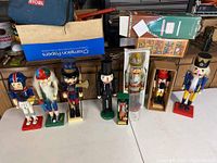 Eight wooden nutcrackers displayed on tabletop showing variety of designs and sizes