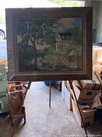 Framed oil painting on easel showing a Virginia countryside scene with house, trees, and lake.