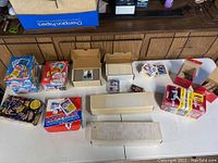 Overview of lot items laid out including sealed wax pack boxes, complete sets in boxes, loose cards, and display boxes