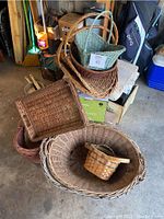Photo showing multiple wicker baskets stacked including a large round laundry basket at the bottom, smaller rectangular baskets stacked inside.