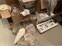 Mixed decorative items on floor including stockings, faux fur pieces, rhinestone ornaments and 'NOEL' sign