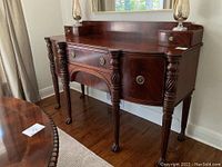 Angled left-front view of entire sideboard showing body, legs, finish and gallery backboard