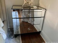 Frontal view showing three mirrored drawers with glass knob pulls