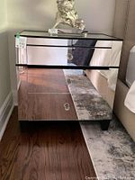 Front view of mirrored chest showing three drawers with glass knobs