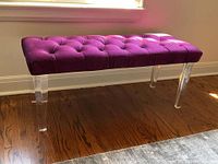 Front view of bench showing full length tufted seat and lucite legs