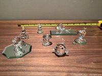 Photo of all seven crystal figurines arranged with ruler in background for size reference