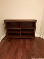 Front view of wooden bookcase with three shelves split into two compartments, showing dark brown finish and rectangular shape.