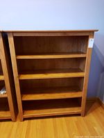 Front view of the O Sullivan wood bookcase showing the four shelves and brown wood finish.