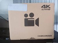 Closed cardboard box labeled 4K Ultra HD Camcorder with a camera icon in black print.