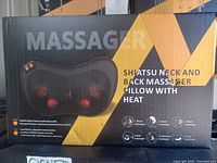Photo of the product box displaying the Shiatsu neck and back massager pillow with heat, showing the product image and features.