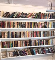 Five shelves of books with a large variety in genres and authors.