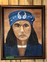 Frontal view of the oil painting depicting a Native American man with a blue headband and a beaded necklace. The painting is framed.