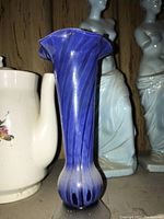 Tall blue glass vase with ruffled top