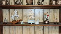 Shelf with all carousel horses, frog figurine, and cherub bowl displayed