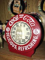 Close-up of red Coca Cola timer with prominent bottle motif and text