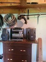 Stereo system with two speakers atop a small wooden chest