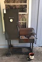 Full view of New Braunfels smoker showing smoker chamber, firebox, and wheeled base