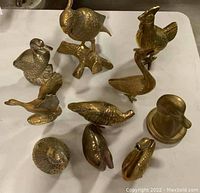 Top view of all 10 brass bird sculptures arranged on display table