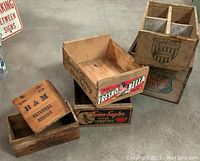Six antique advertising wooden crates stacked and laid on floor showing labels and crate condition